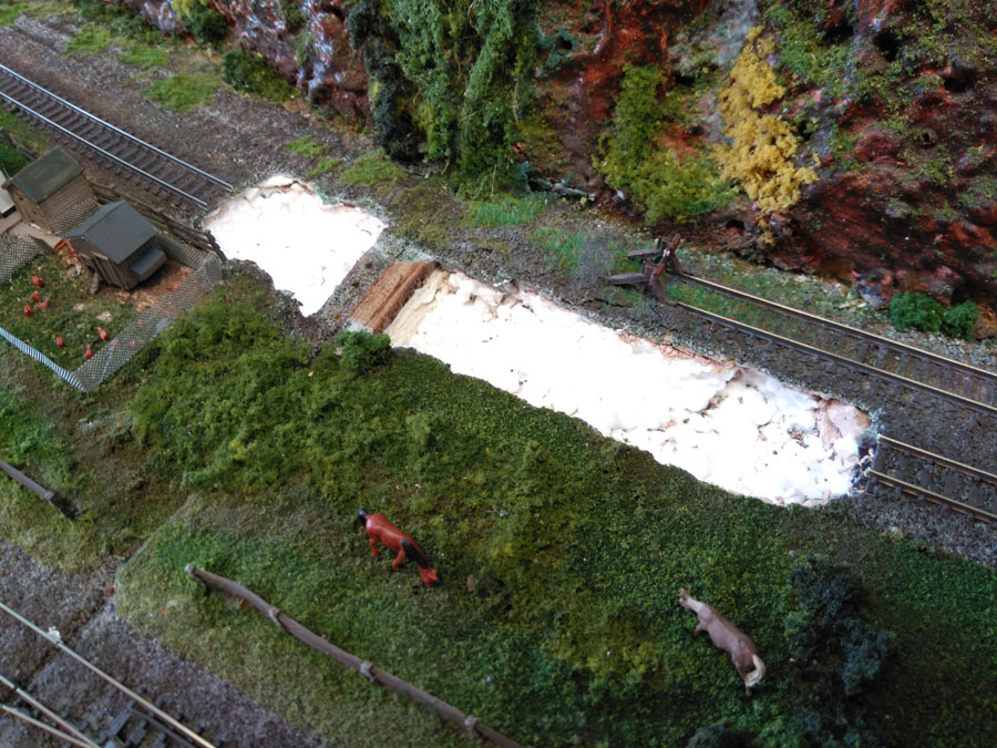 The branch line itself has suffered subsidence at the board join so it required repair. The affected area was excavated to find just a thin skin of plaster over polystyrene. The loose material was dug out and the area was filled with car body filler. Then the track was relaid and reballasted: