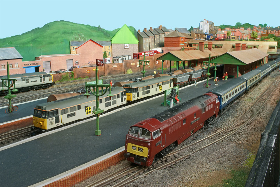 'Western' Class 52 No D1015 in maroon livery pauses with an Inter City express while a Class 31 double-headed mineral freight occupies the central road, consisting of No 31 130 at the front and No 31 201 at the back.