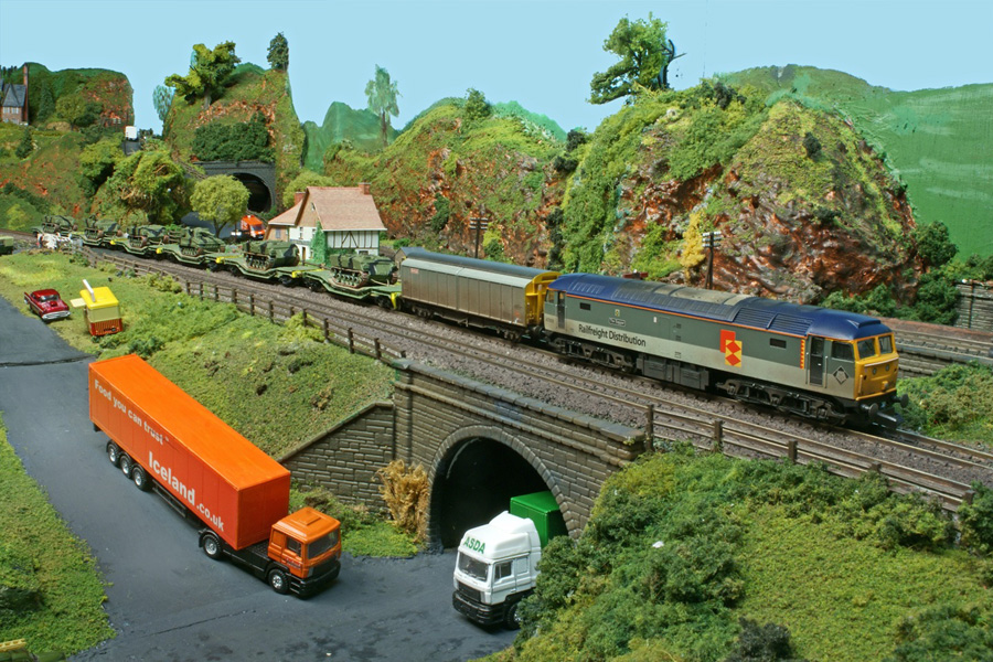 A train of military vehicles and associated stores passes over the bridge, with Railfreight Distribution Class 47 No 47 306 'The Sapper' appropriately in charge.