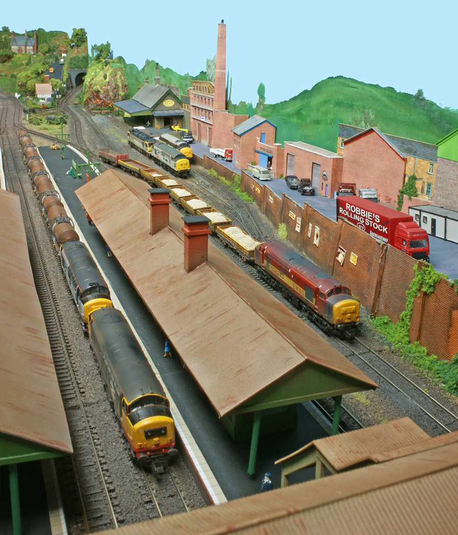 Three Class 37s rumble through Bridgebury Gate at the same time, with a double-header leading an oil tanker freight on the main line and an EWS permanent way service held back in one of the loop lines.