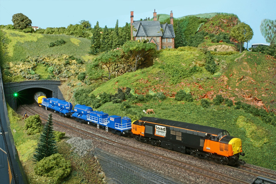 Class 37 No 37 513 in full Load Haul livery shares haulage duties with another Class 37 of a Network Rail track treatment train.